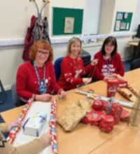 Image of Catherine Jowitt wrapping gifts for inpatients with volunteers
