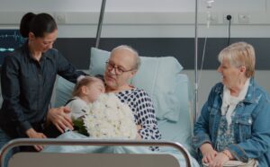 Photograph of family members with elderly relative in hospital