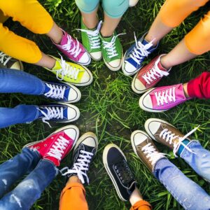 Photograph of circle of feet wearing colourful sneakers