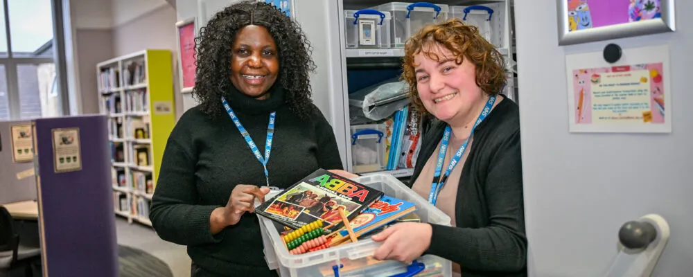 Image of two women holding a box of jigsaws