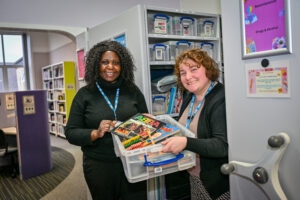 Image of two women holding a box of jigsaws