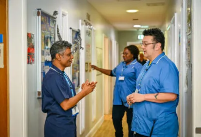 Image of three people stood in a corridor