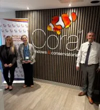 Image of three people stood in front a wall