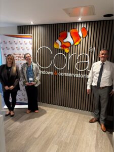 Image of three people stood in front a wall