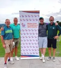 Image of four men stood next to a banner
