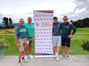 Image of four men stood next to a banner